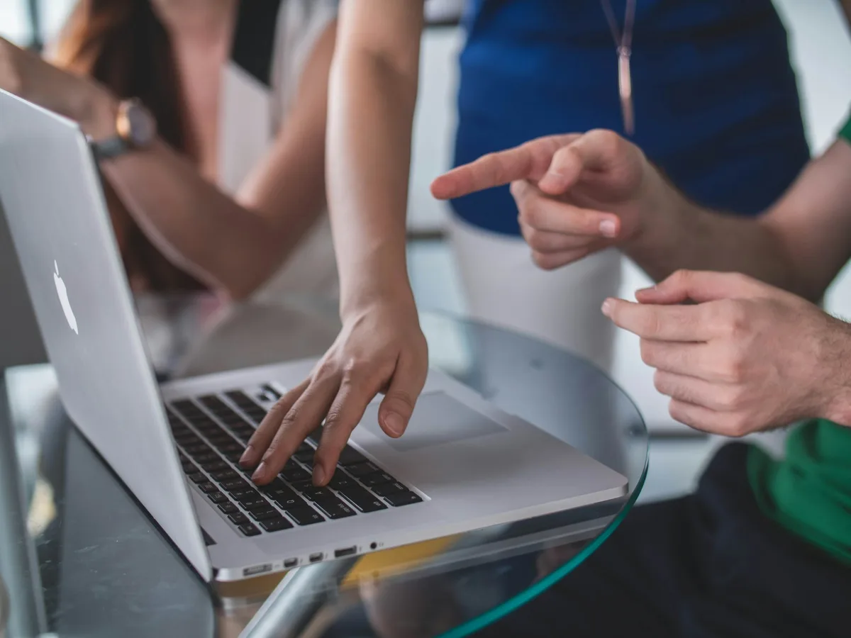 Hände an einem Laptop, gemeinsames Ausprobieren im Kurs